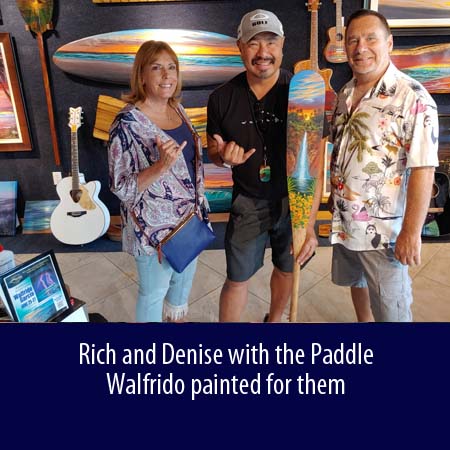 Rich and Denise with the Paddle Walfrido painted for them-Wyland Gallery Sarasota